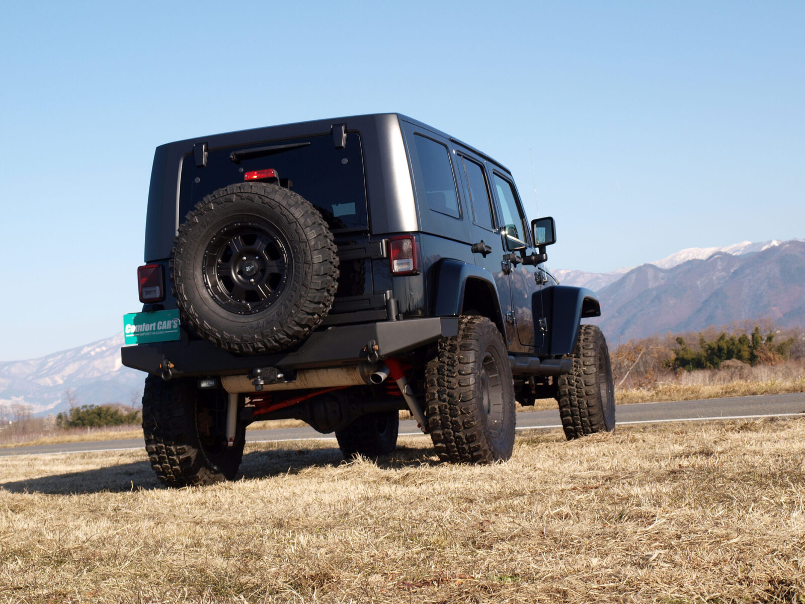 JK WRANGLER UNLIMITED COMFORT CAR'S スペアタイヤを背負ったリアビューが、タフなイメージを演出。