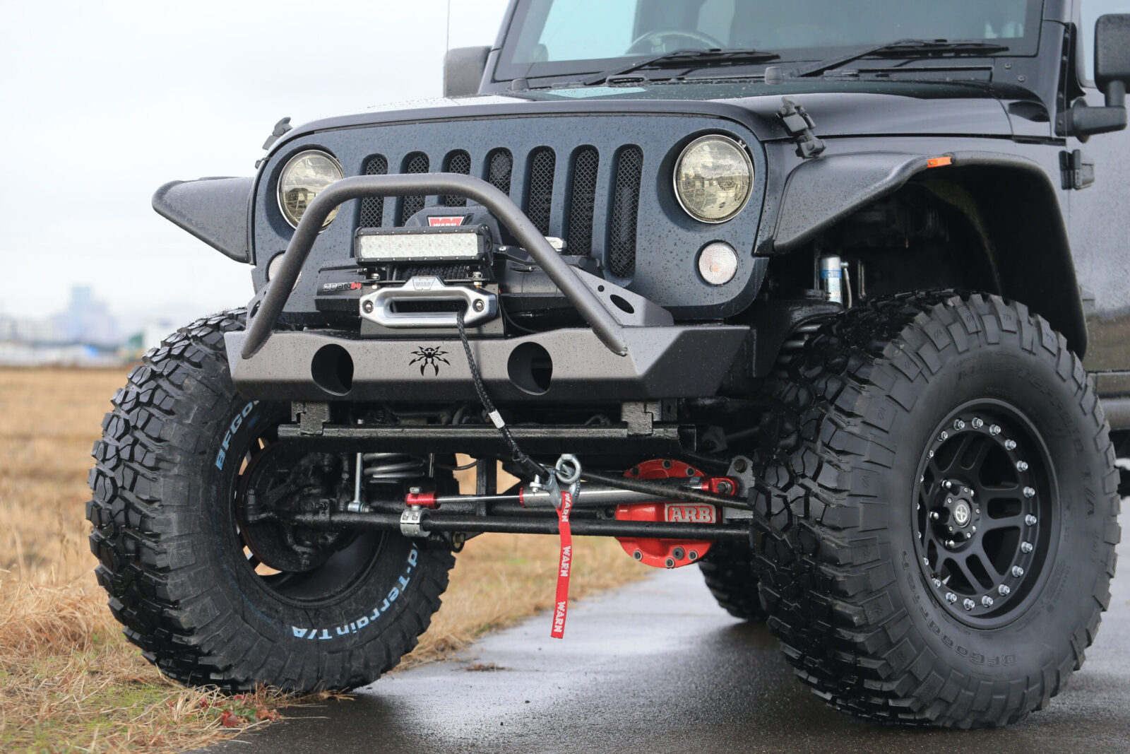 JK WRANGLER UNLIMITED CRD GRAVEL AUTO SERVICE ポイズンスパイダーのブロウラーバンパーとウォーンウインチの組み合わせが見せる逞しいフロント回りは、シンプルな中にも力感十分。独特な形状のバンパーはウインチガード的な役割も果たす。