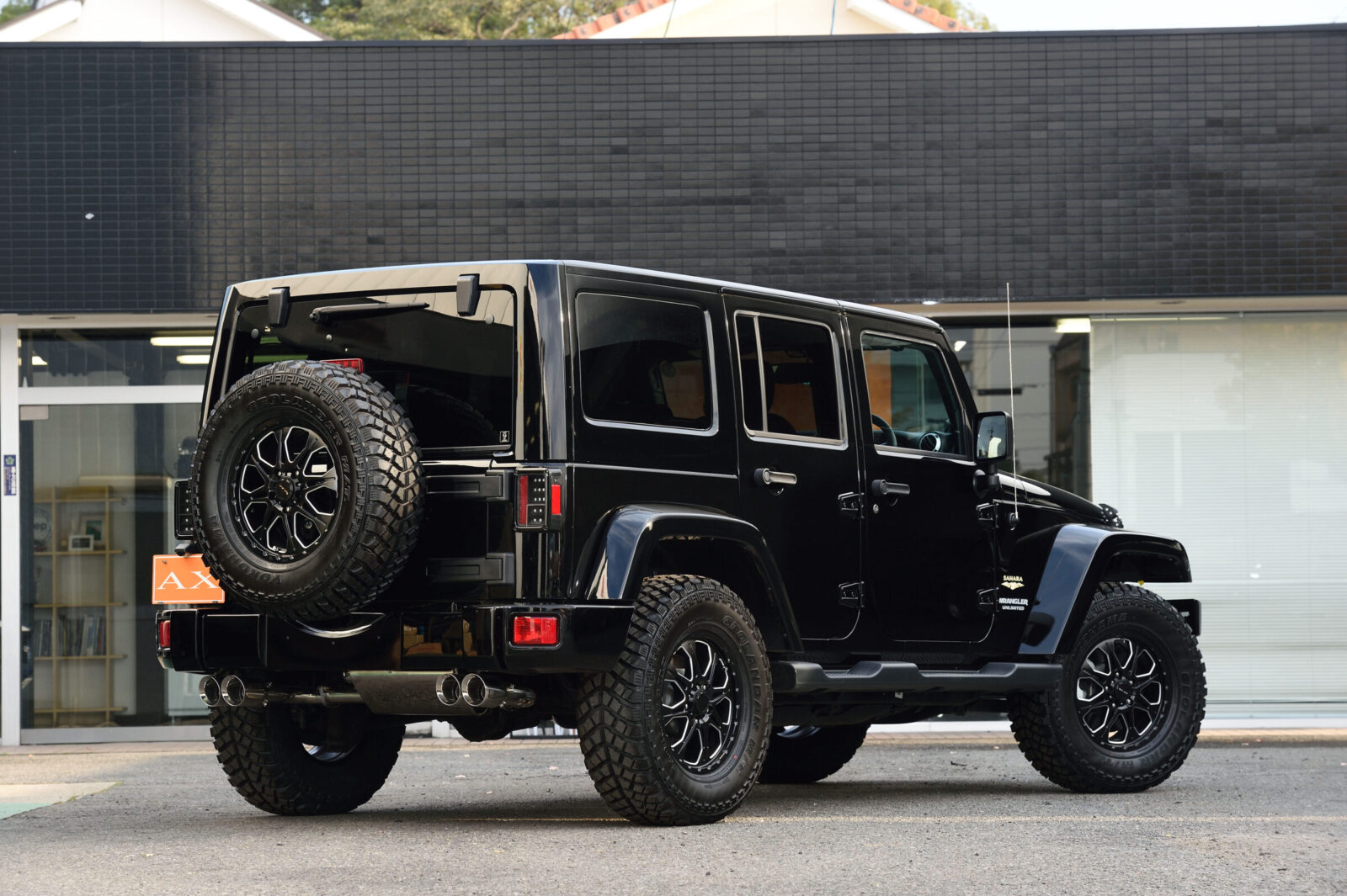 JK WRANGLER UNLIMITED Black Edition AX ホイールはもちろん、サイドマーカーもスモークとするなど、とことんまでブラックを追求している。オリジナルの4本出しマフラーがリアビューにさらなる迫力を与えている。