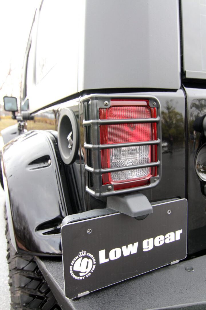 JK WRANGLER UNLIMITED LOW GEAR USナンバーステーを装着するとともに、テールランプガードを装着し、ワイルドな雰囲気を強調。