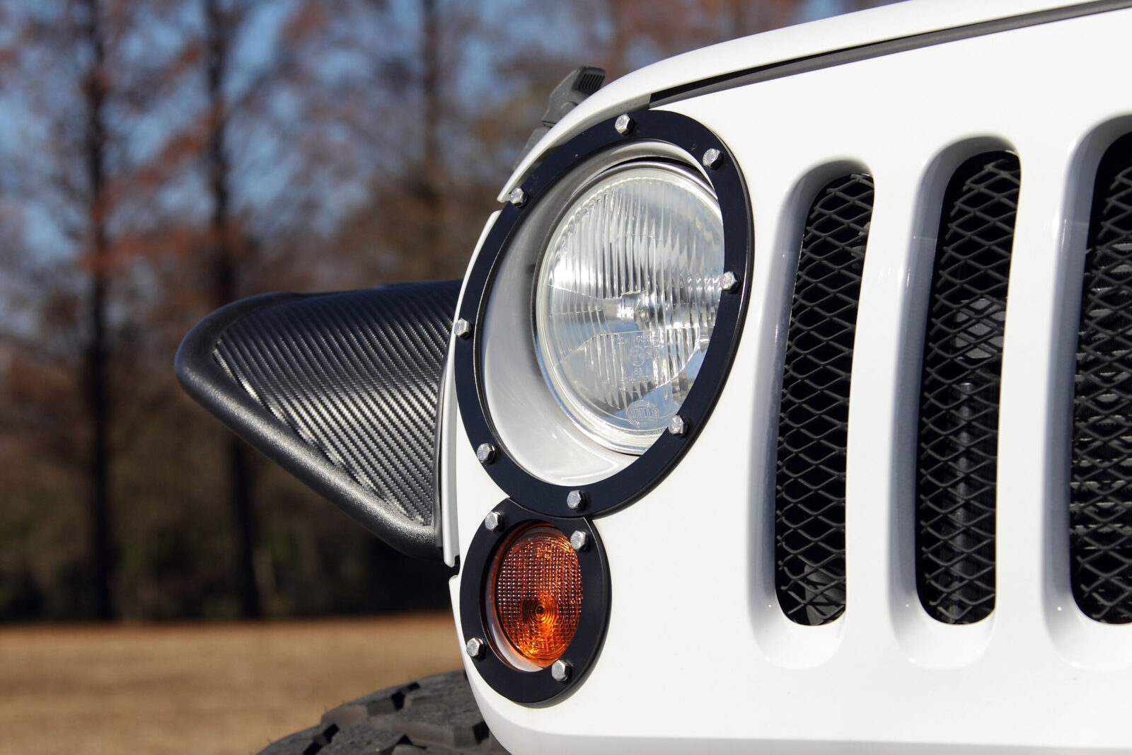 JK WRANGLER UNLIMITED 88 HOUSE MARINE WAVE フロントライトトリムは4ピース構成。ボルトヘッドの素材感がワイルドさを強調する。ヘッドライトはHIDに換装。